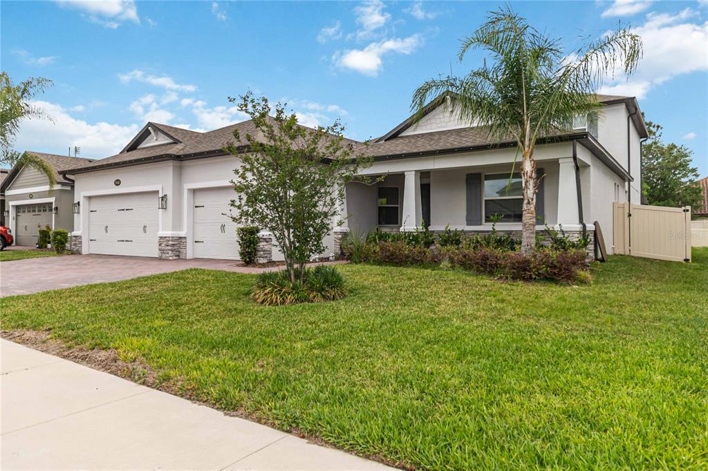 A two-story suburban house with a two-car garage, front porch, and a palm tree — 2510 CEDAR SHAKE COURT, OVIEDO, FL