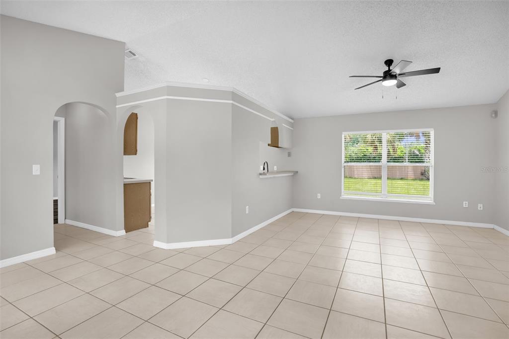 An open-concept living area features light gray walls, beige tile flooring, and a ceiling fan — 14520 LYCASTLE CIRCLE, ORLANDO, FL