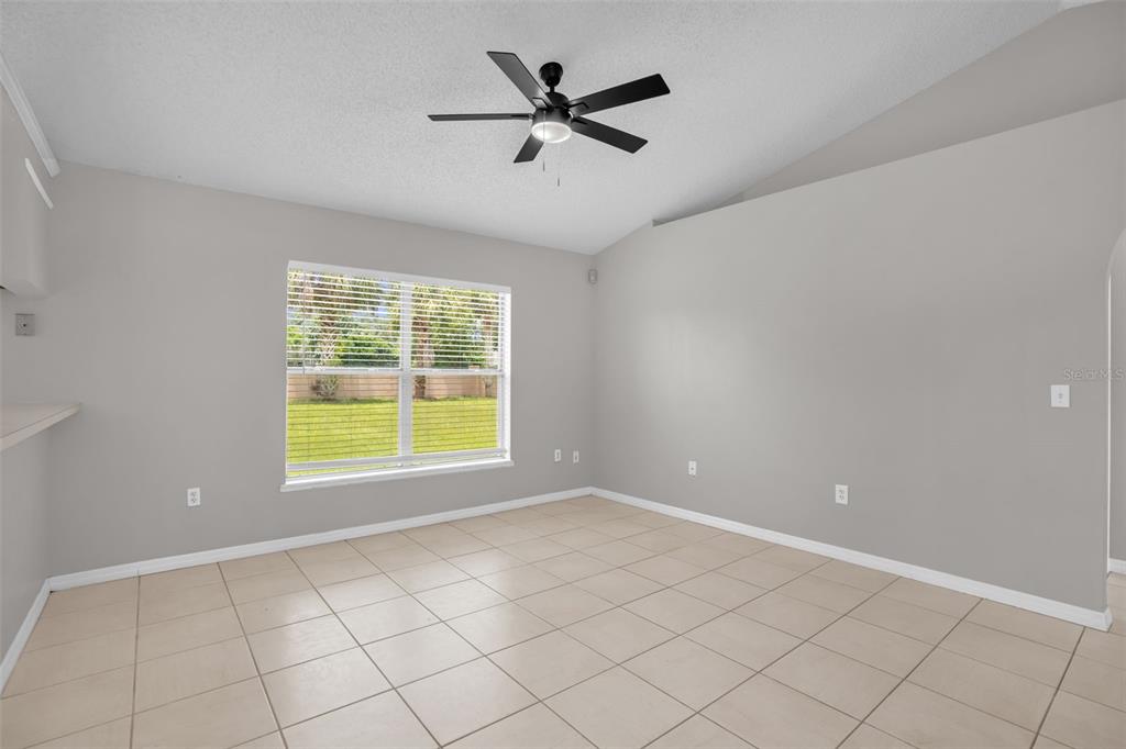 An empty room features light gray walls, beige tile flooring, and a ceiling fan — 14520 LYCASTLE CIRCLE, ORLANDO, FL