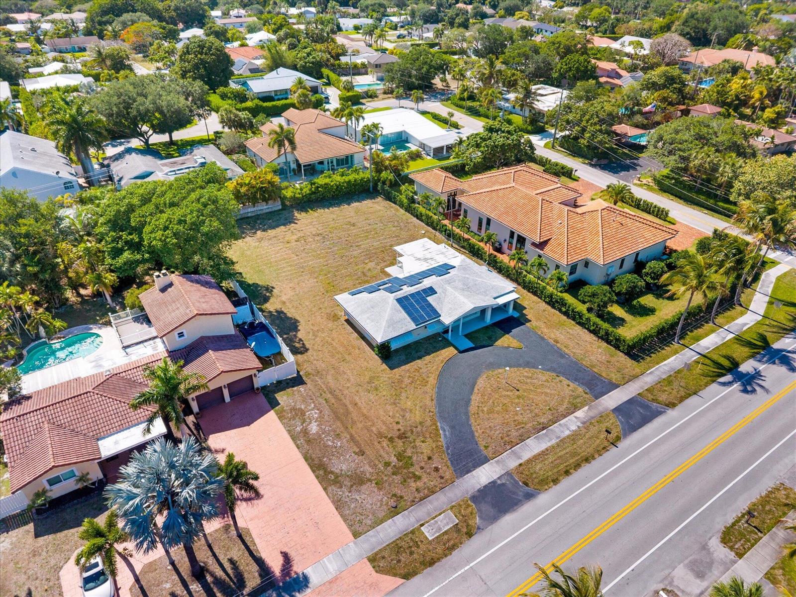 An aerial view shows a single-story house with solar panels on a large grassy lot — 1035 NW 4th Avenue, Boca Raton FL 33432, BOCA RATON, FL