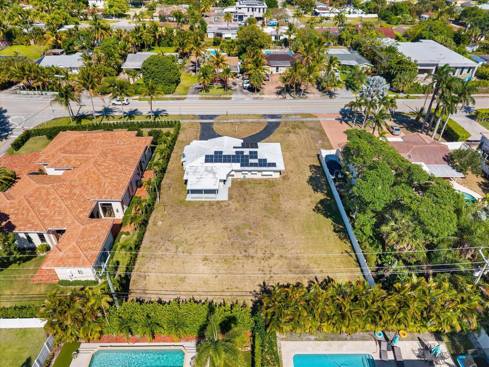 An aerial view shows a single-story house with solar panels on a large, grassy lot — 1035 NW 4th Avenue, Boca Raton FL 33432, BOCA RATON, FL