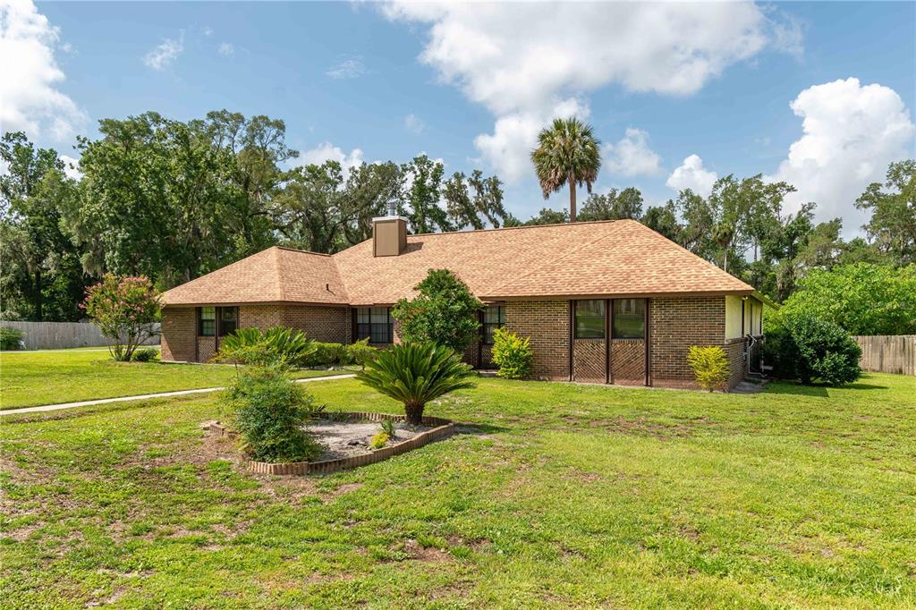 A single-story brick house with a shingled roof sits on a grassy lot with trees — 3555 SW 24TH AVENUE ROAD, OCALA, FL