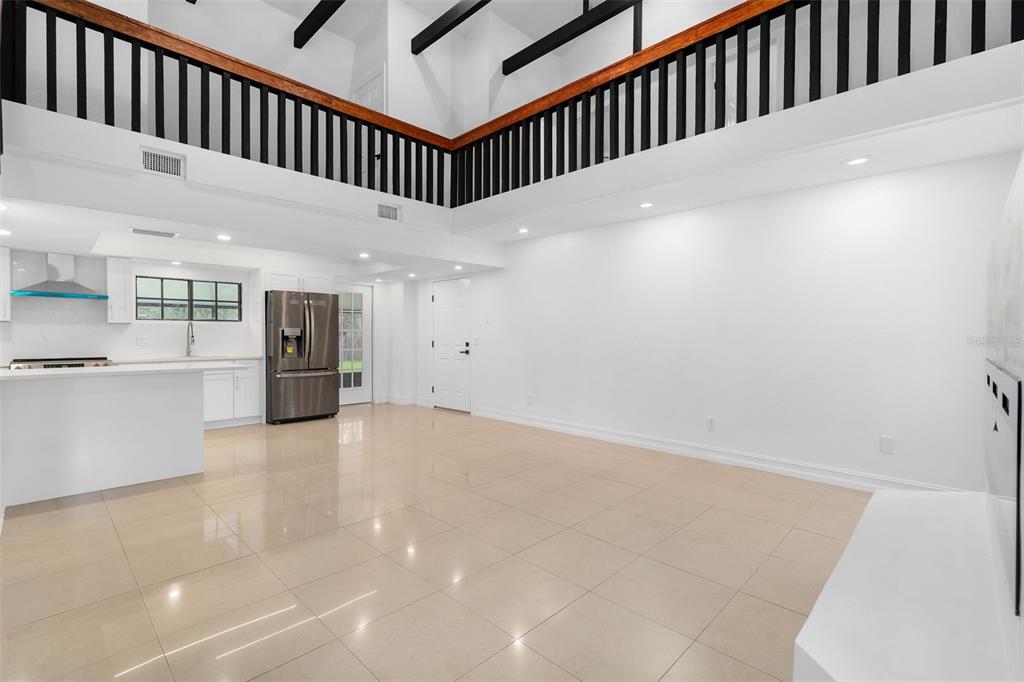 A spacious living room with a high ceiling, white walls, and a large sectional sofa — 4221 GREENFERN DRIVE, ORLANDO, FL