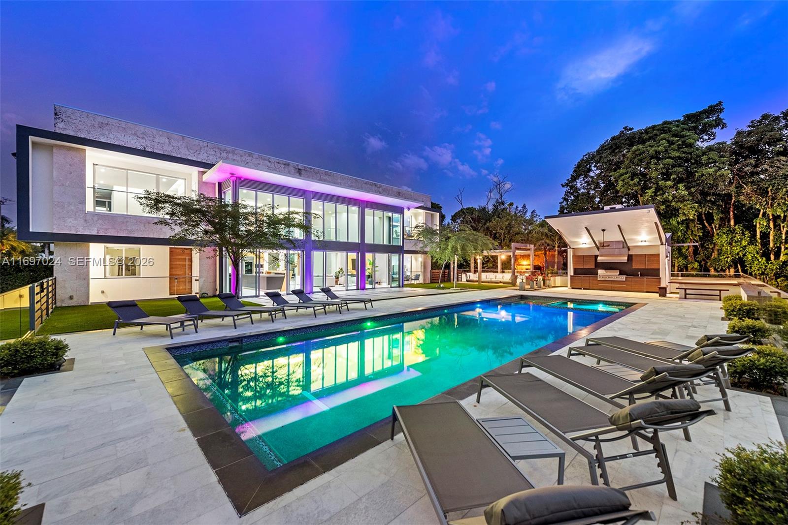 A modern two-story house features a large swimming pool, lounge chairs, and an outdoor kitchen — 14305 Stirling Rd, Southwest Ranches FL 33330, SOUTHWEST RANCHES, FL