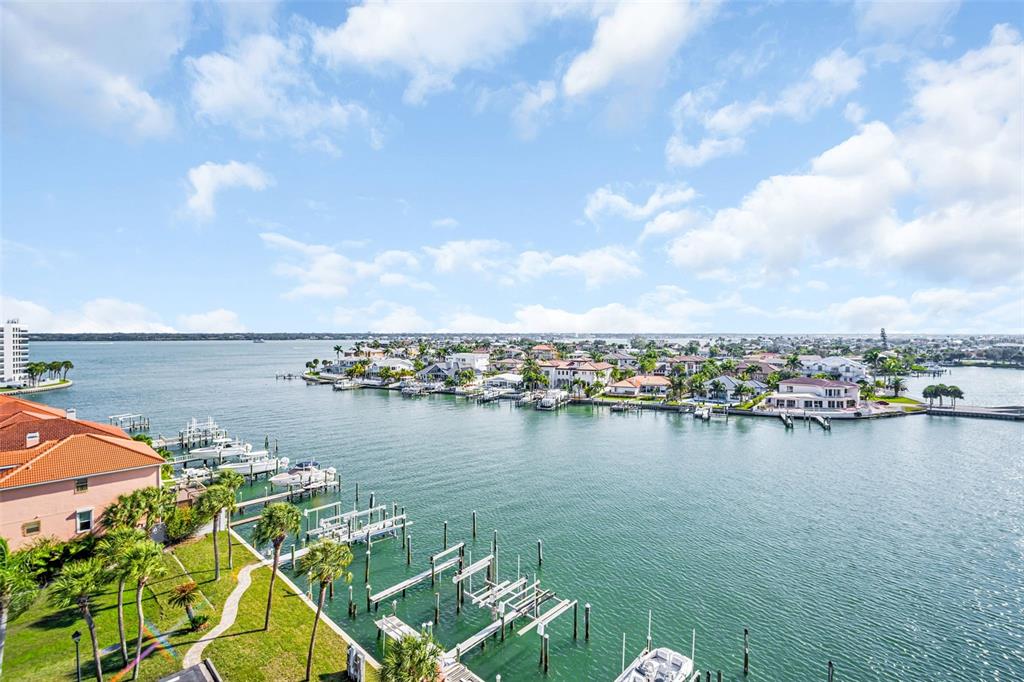 An aerial view shows a waterfront residential area with docks, boats, and houses — 1651 SAND KEY ESTATES CT UNIT 74, CLEARWATER BEACH, FL