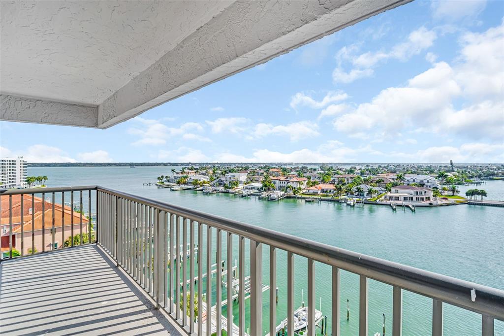 A balcony with a metal railing overlooks a bay with houses and boats — 1651 SAND KEY ESTATES CT UNIT 74, CLEARWATER BEACH, FL