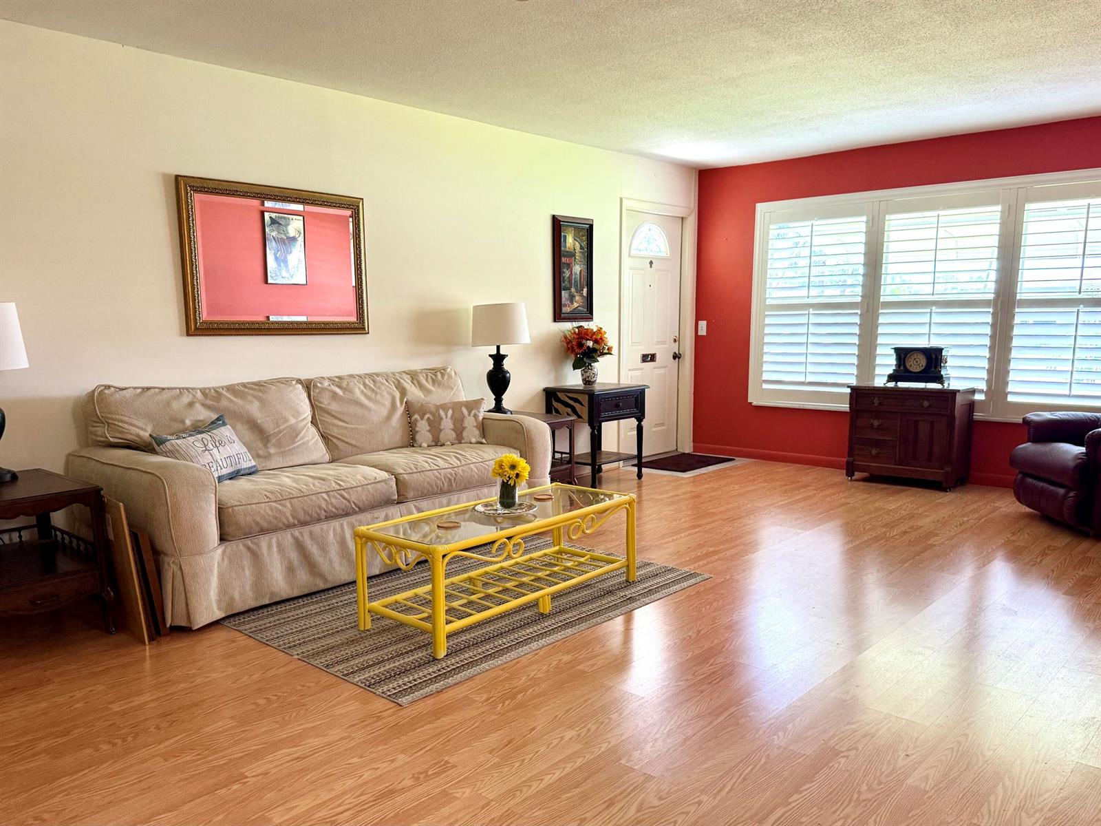A living room features a beige sofa, a yellow coffee table, and a red accent wall — 215 South Boulevard # C, Boynton Beach FL 33435, BOYNTON BEACH, FL