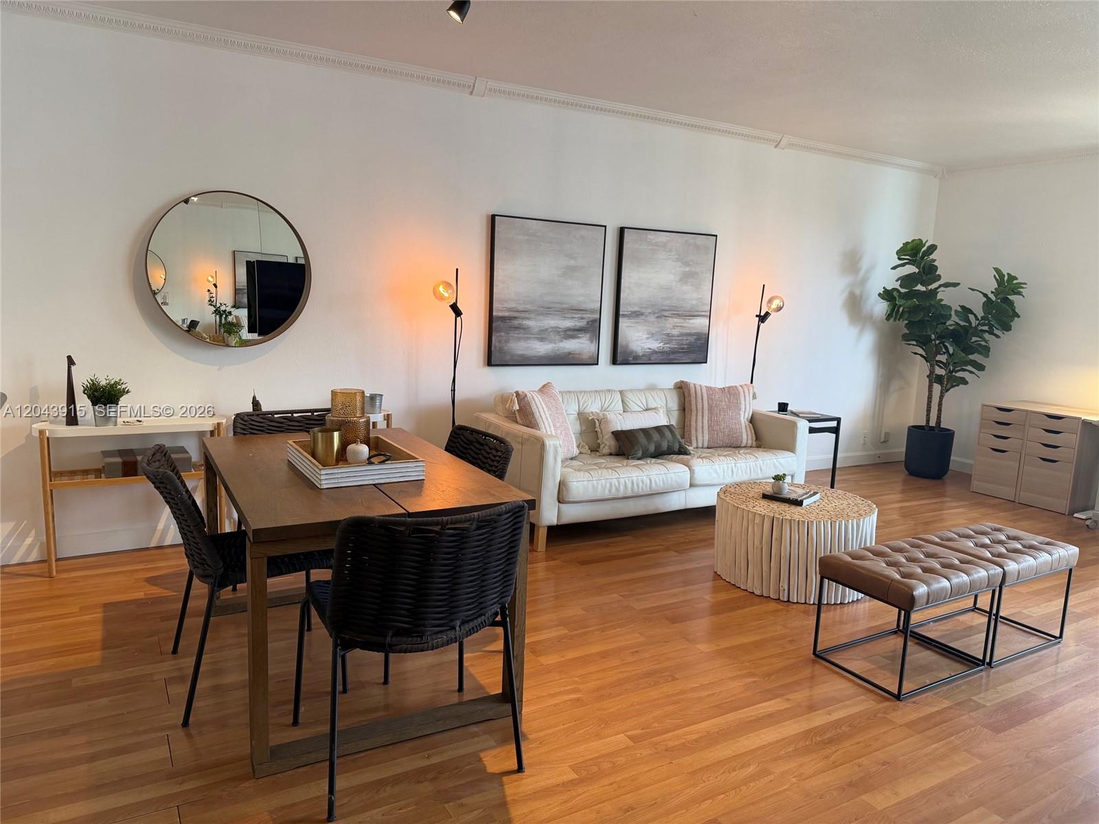A living and dining room area features wood floors, a white sofa, and modern decor — 520 Brickell Key Dr # A1412, Miami FL 33131, MIAMI, FL
