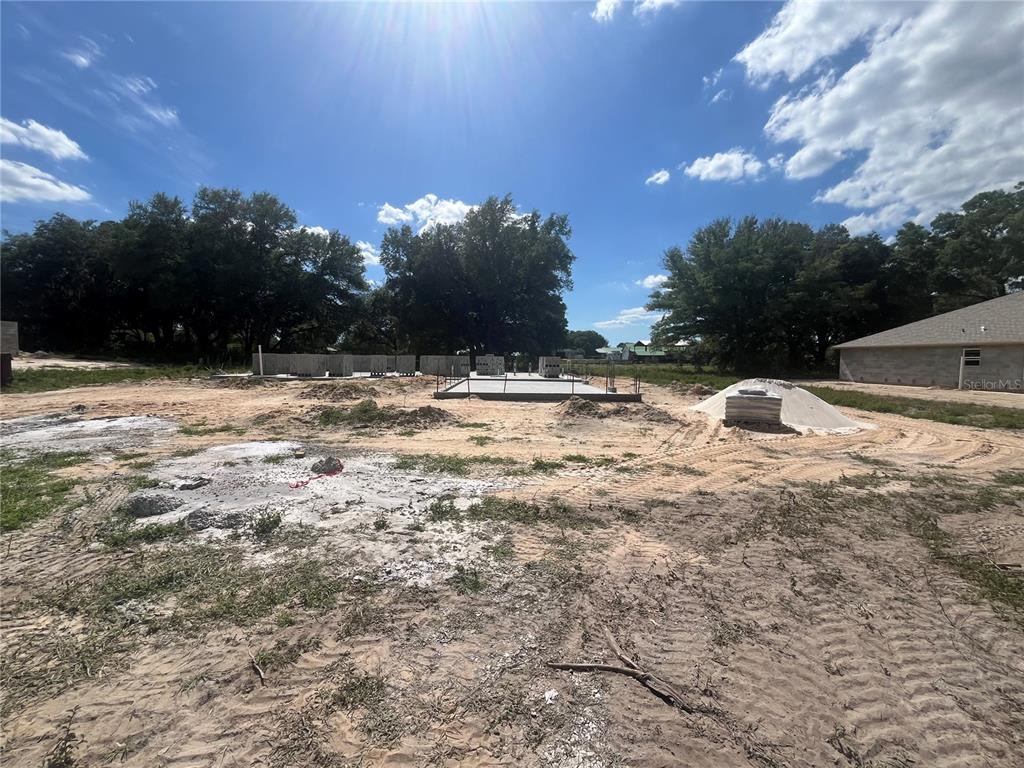 A single-story house under construction with concrete block walls and a dark shingled roof — 16832 SE 23RD AVENUE, SUMMERFIELD, FL