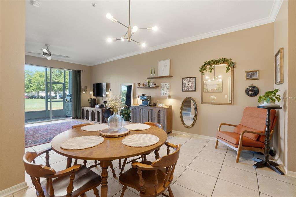 A dining area features a round wooden table, tile flooring, and an adjacent sitting nook — 3028 CAPRI ISLE WAY, ORLANDO, FL