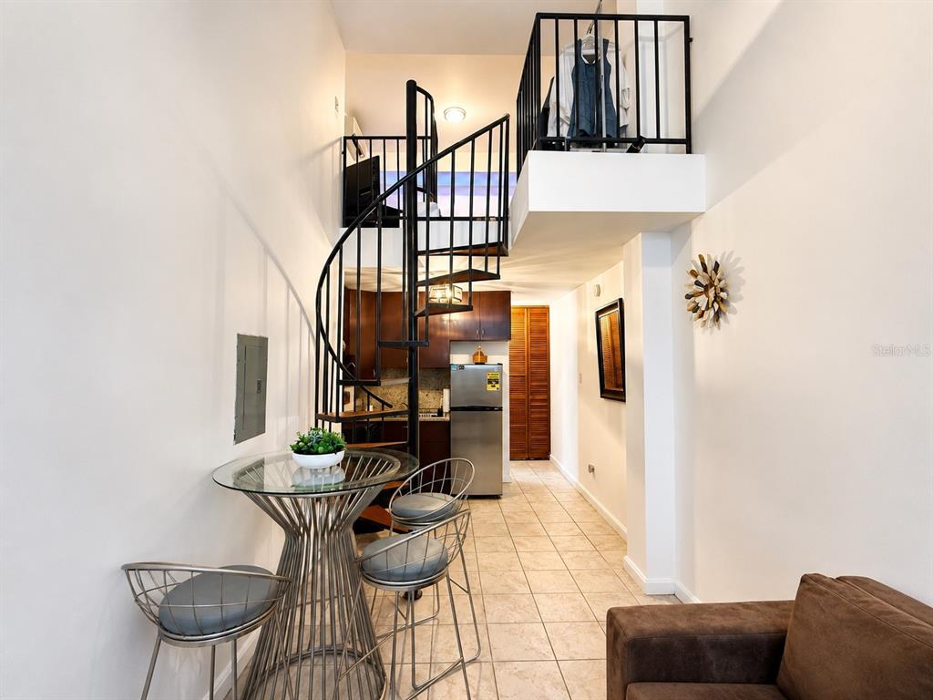 A living room features a spiral staircase, a loft area, tile floors, and a sofa — 315 Tetuan Street GAMBARO UNIT 1-B, SAN JUAN, PR