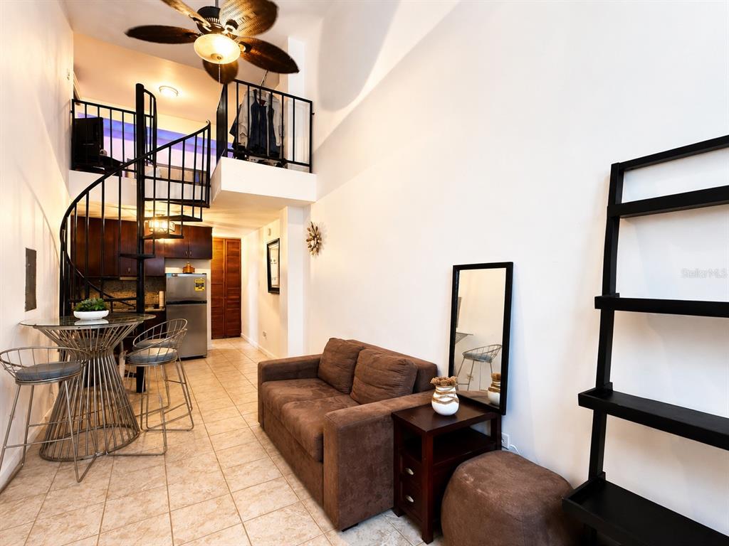 A bedroom features a dark wood bed frame, a matching dresser, and light-colored tile flooring — 315 Tetuan Street GAMBARO UNIT 1-B, SAN JUAN, PR