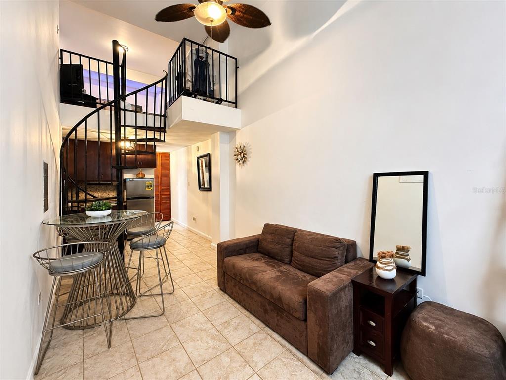 A bathroom with a toilet and shelves next to a closet containing a stacked washer-dryer — 315 Tetuan Street GAMBARO UNIT 1-B, SAN JUAN, PR
