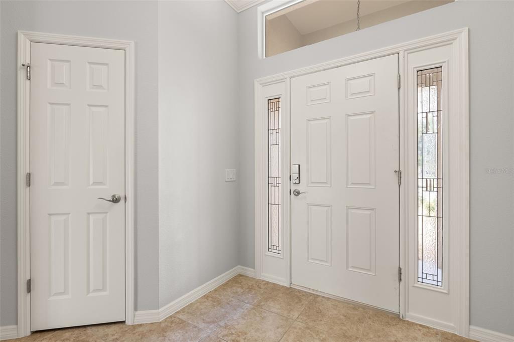 An entryway features a white front door with sidelights, a side door, and tile flooring — 842 PICKETT ROAD, THE VILLAGES, FL
