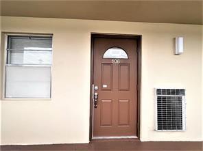A brown front door labeled 106 sits next to a window and an air conditioner — 7300 NW 5th Court # 106, Margate FL 33063, MARGATE, FL