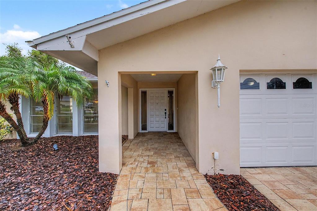 A paved walkway leads to the front entrance of a house with a white garage — 14317 110TH TERRACE, LARGO, FL