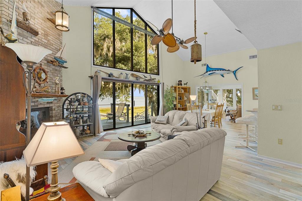 A sunset view over a lake framed by silhouetted trees and Spanish moss — 15562 SE 138TH TERRACE, WEIRSDALE, FL