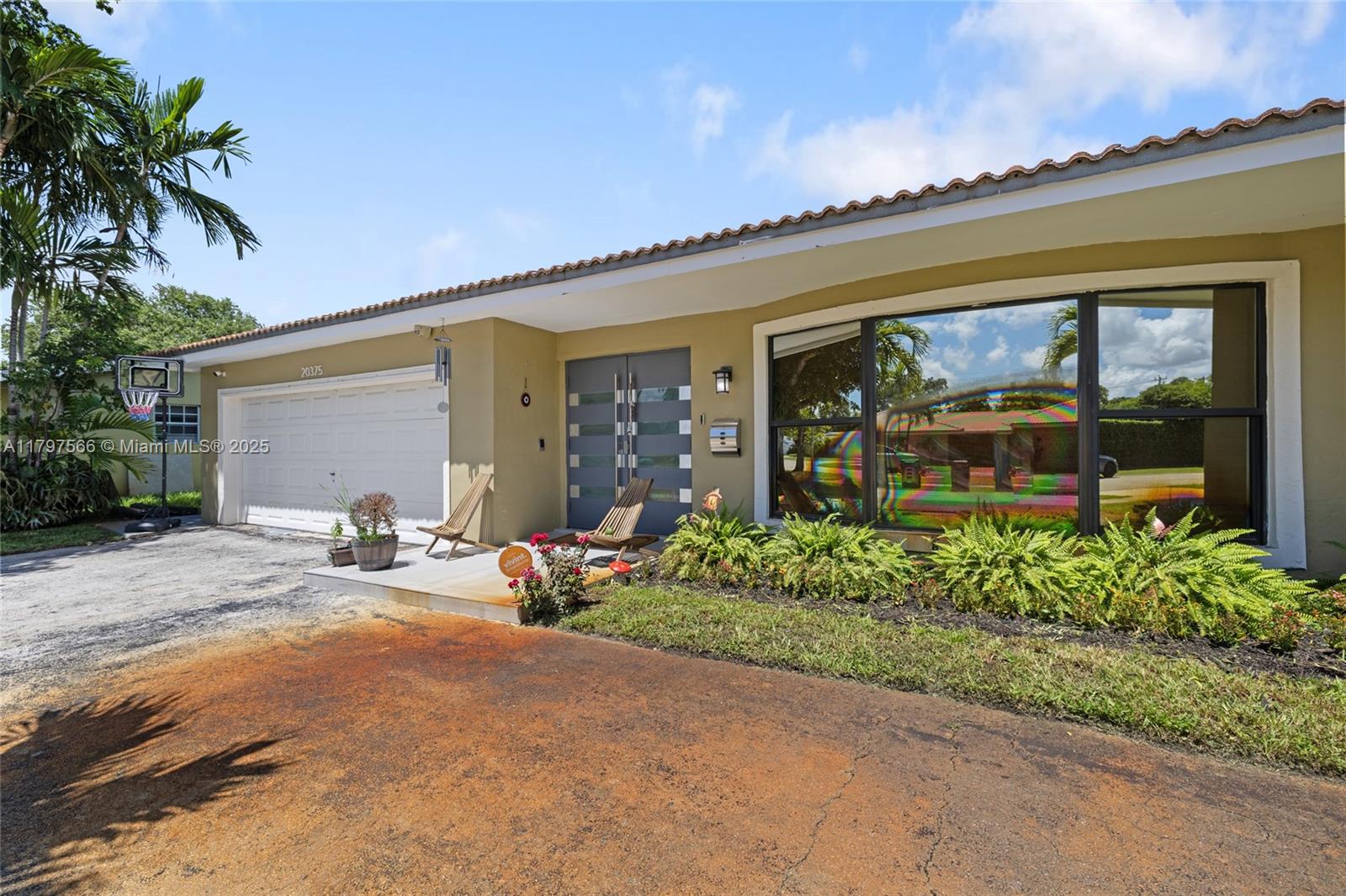 A single-story house exterior features a garage, a double front door, and a large window — 20375 NE 22nd Pl, Miami FL 33180, MIAMI, FL