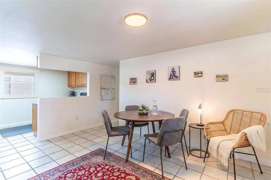 A dining area features a round wooden table, four gray chairs, and a wicker accent chair — 225 W NORTHSIDE DRIVE, LAKE WALES, FL
