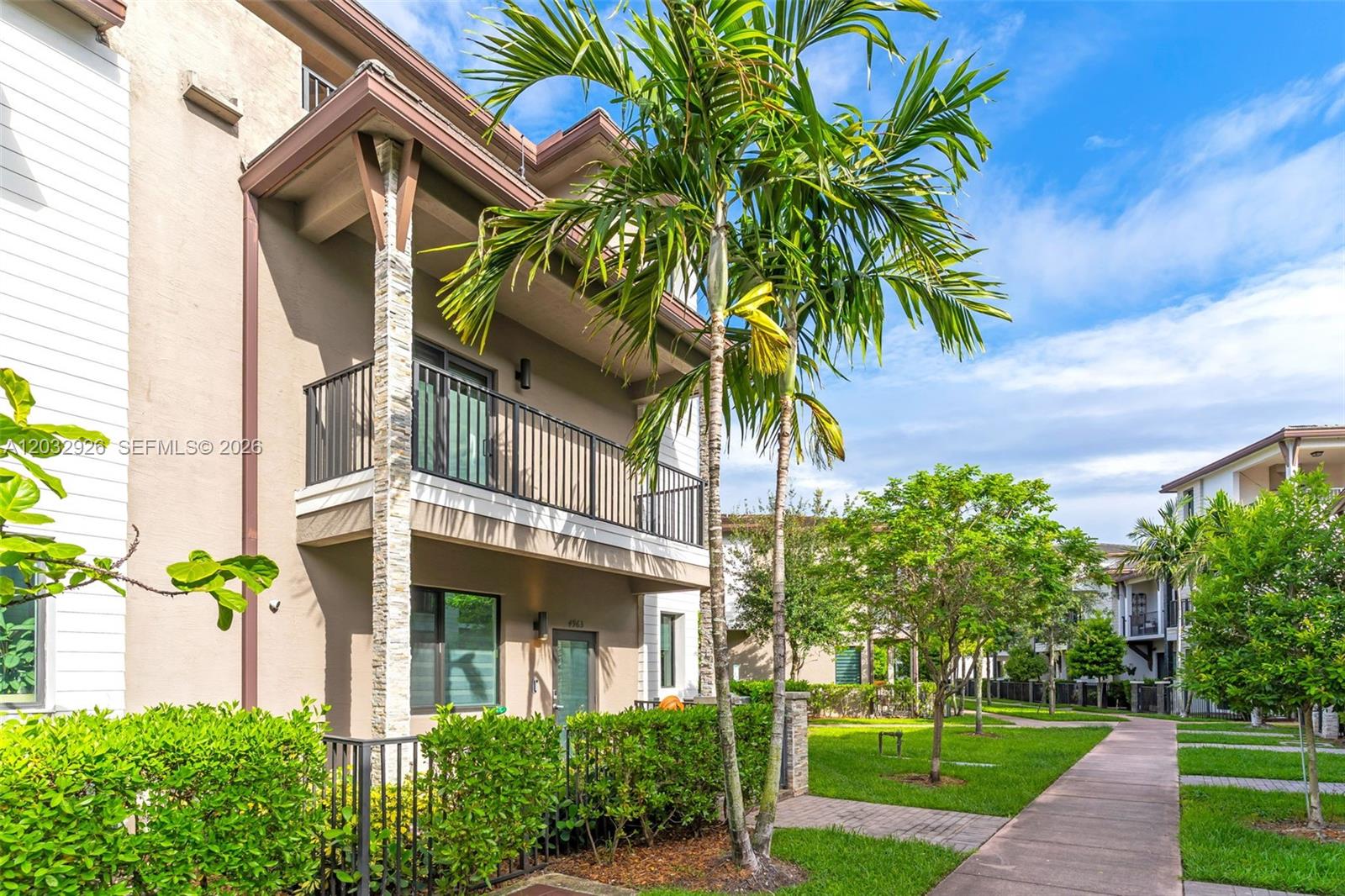 A multi-story townhouse exterior features a balcony, stone-accented columns, and a landscaped walkway — 4963 NW 83rd Path # 4963, Doral FL 33166, DORAL, FL