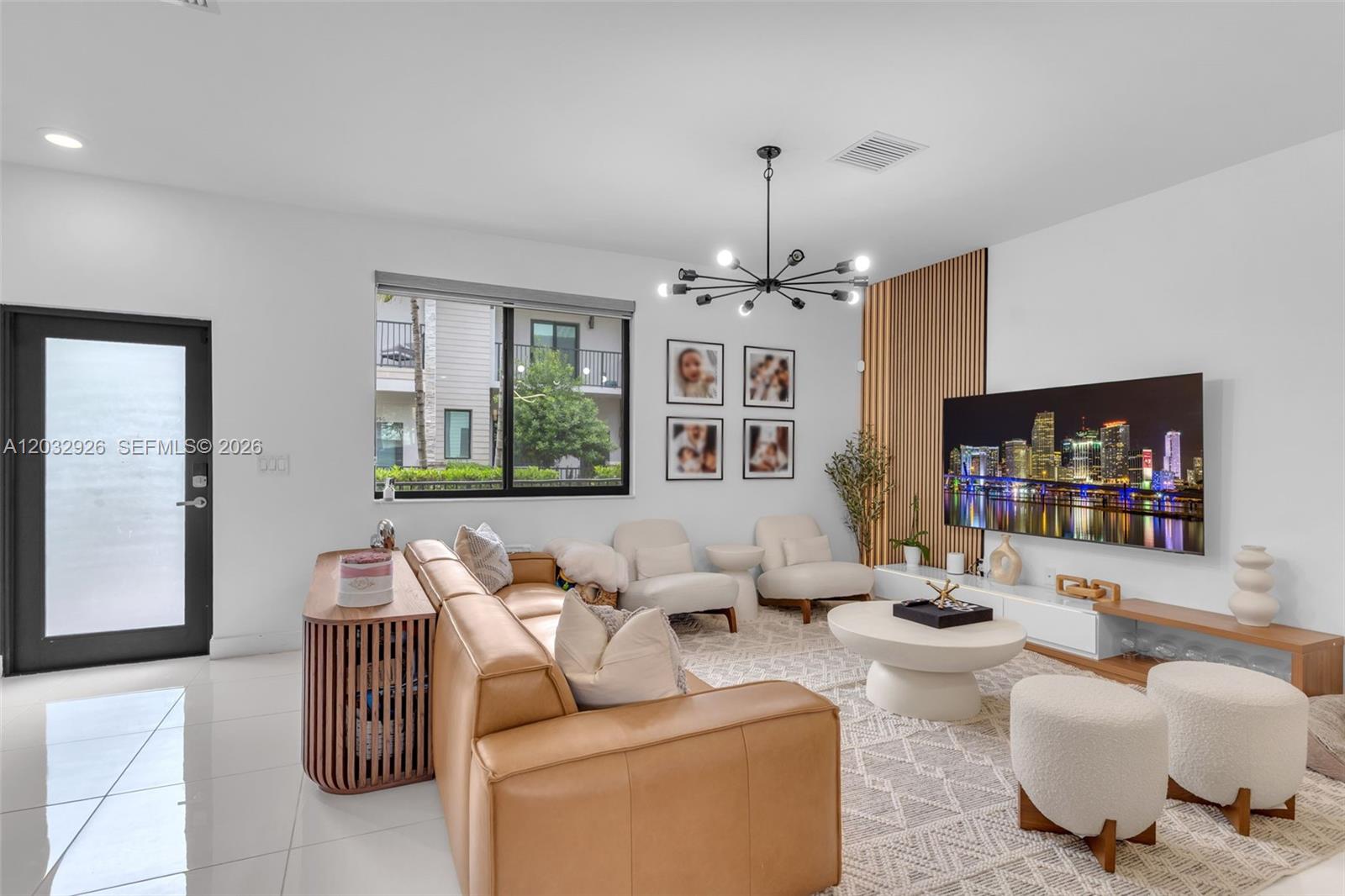 A modern living room features a tan leather sofa, slatted wood wall paneling, and a television — 4963 NW 83rd Path # 4963, Doral FL 33166, DORAL, FL