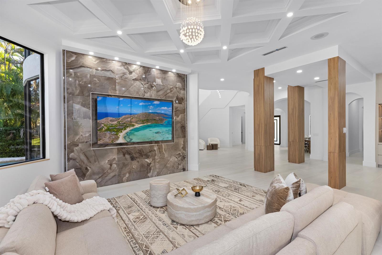 A modern living room features a large stone accent wall, coffered ceiling, and wood columns — 17606 Circle Pond Court, Boca Raton FL 33496, BOCA RATON, FL