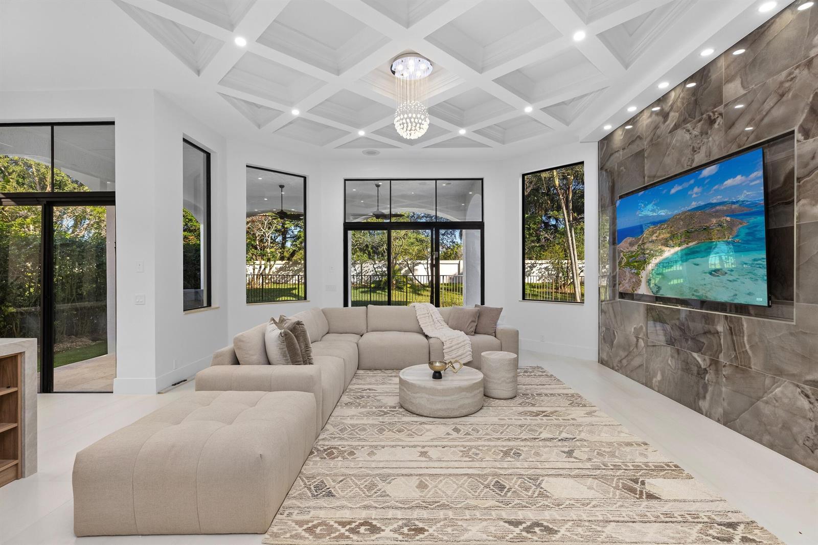 A modern living room features a coffered ceiling, a large sectional sofa, and a stone-tiled wall — 17606 Circle Pond Court, Boca Raton FL 33496, BOCA RATON, FL