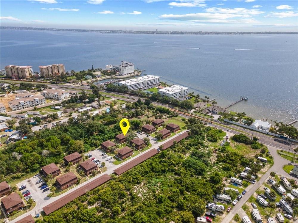 An aerial view shows a residential complex with brown buildings near a large body of water — 4414 OVERLOOK DRIVE NE UNIT 18, PALM BAY, FL