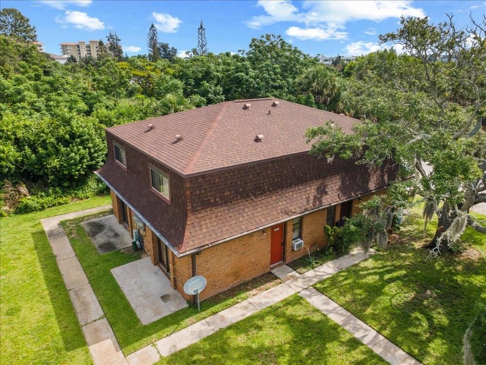 An aerial view of a two-story brick building with a brown shingled mansard roof — 4414 OVERLOOK DRIVE NE UNIT 18, PALM BAY, FL