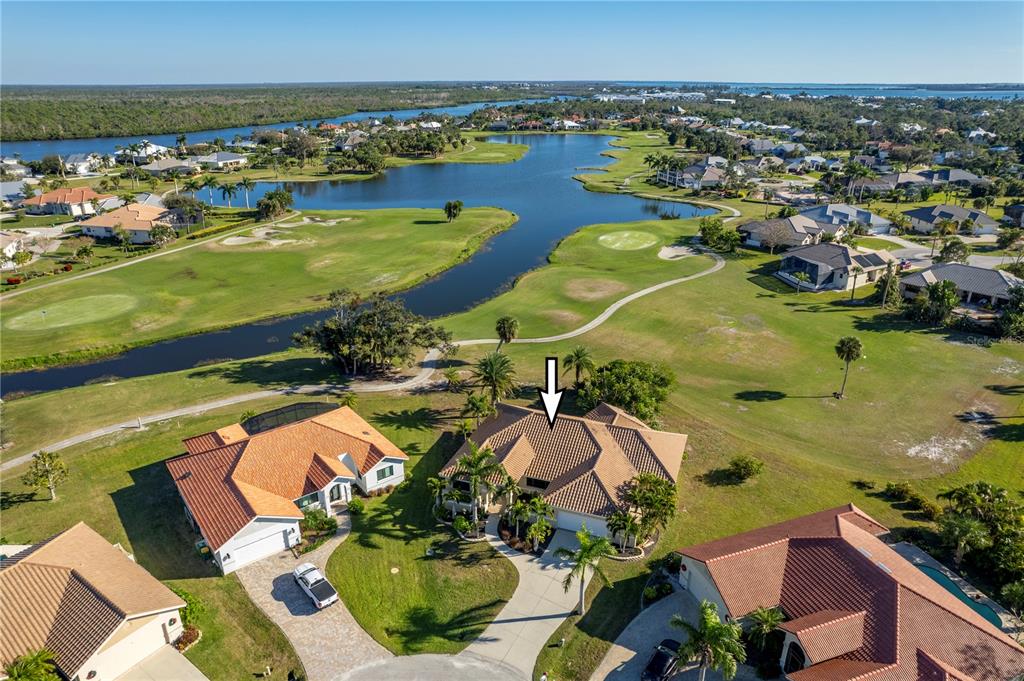 An aerial view shows a house with a tile roof situated on a golf course — 13 SEAWARD CIRCLE, PLACIDA, FL