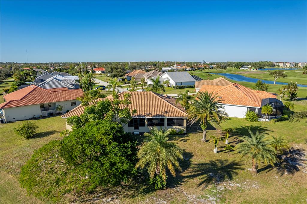 An aerial view shows several single-family homes with tile roofs surrounded by lawns and palm trees — 13 SEAWARD CIRCLE, PLACIDA, FL