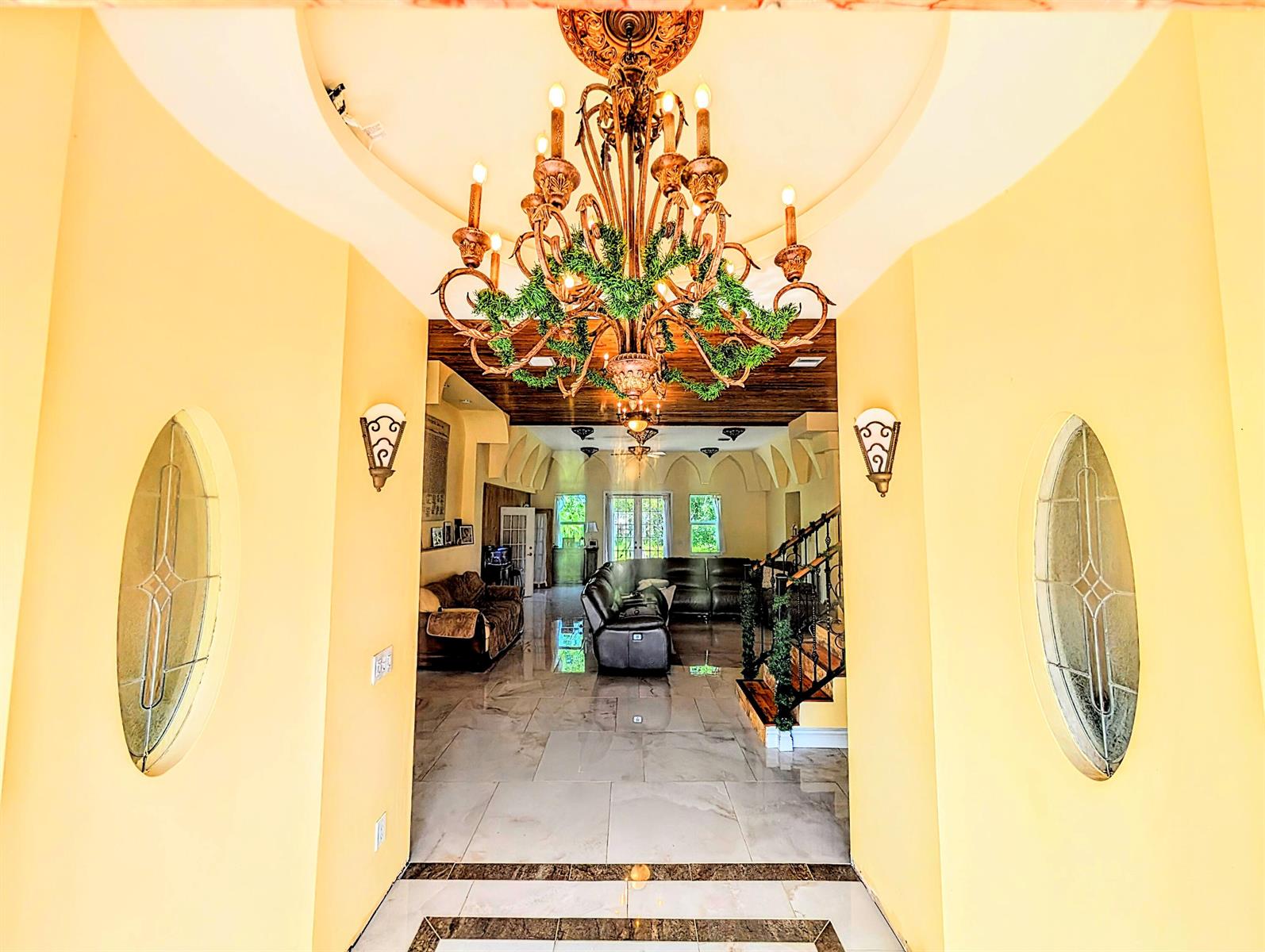 A foyer with a large chandelier leads into a living room with tiled floors — 17681 93rd Road N, Loxahatchee FL 33470, LOXAHATCHEE, FL