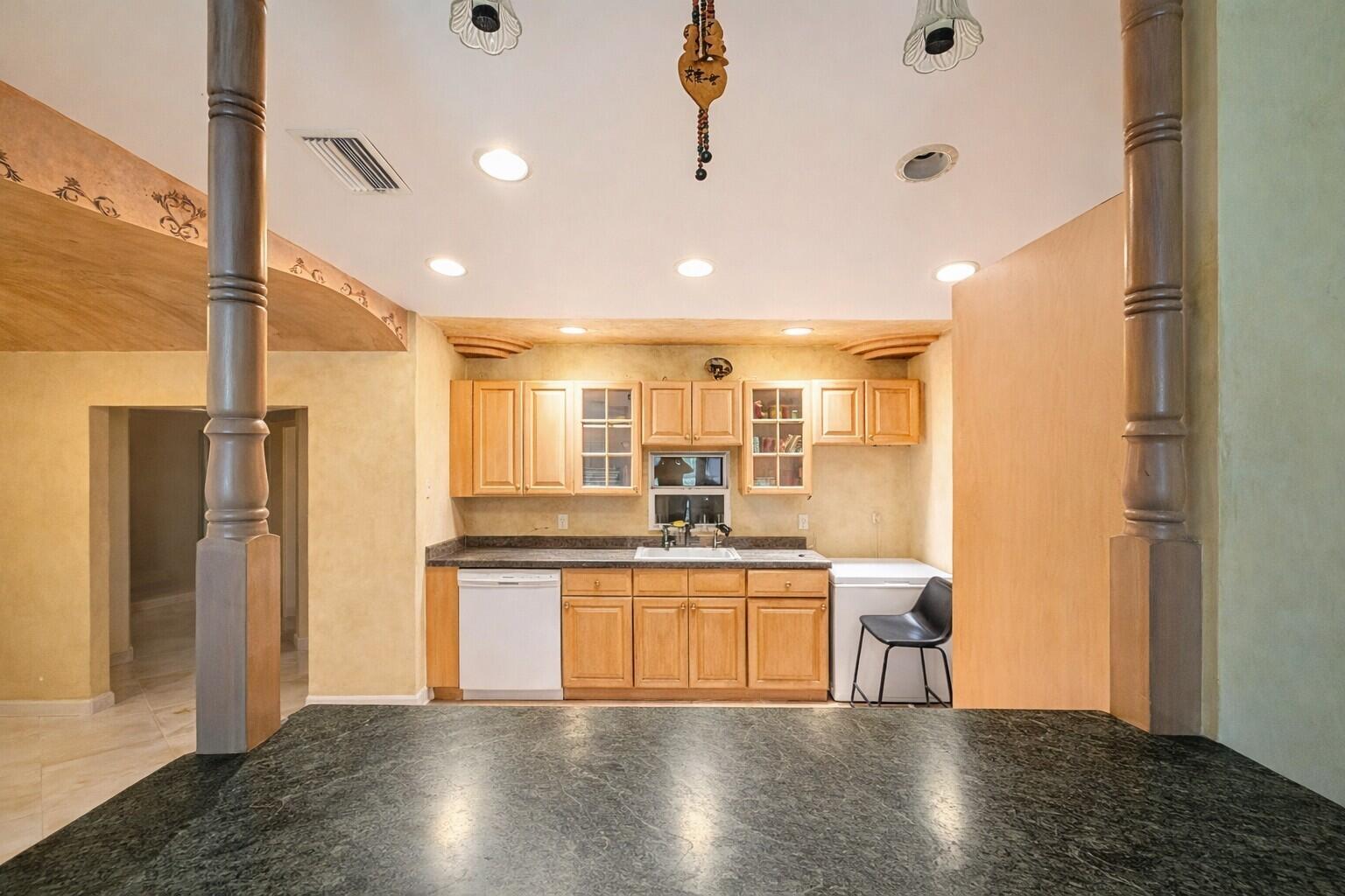 A kitchen features light wood cabinets, dark countertops, a dishwasher, and a chest freezer — 17681 93rd Road N, Loxahatchee FL 33470, LOXAHATCHEE, FL