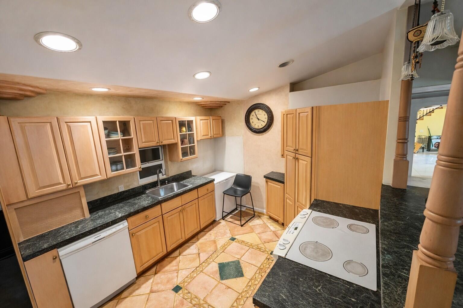 A kitchen with light wood cabinets, dark green countertops, and tiled flooring — 17681 93rd Road N, Loxahatchee FL 33470, LOXAHATCHEE, FL