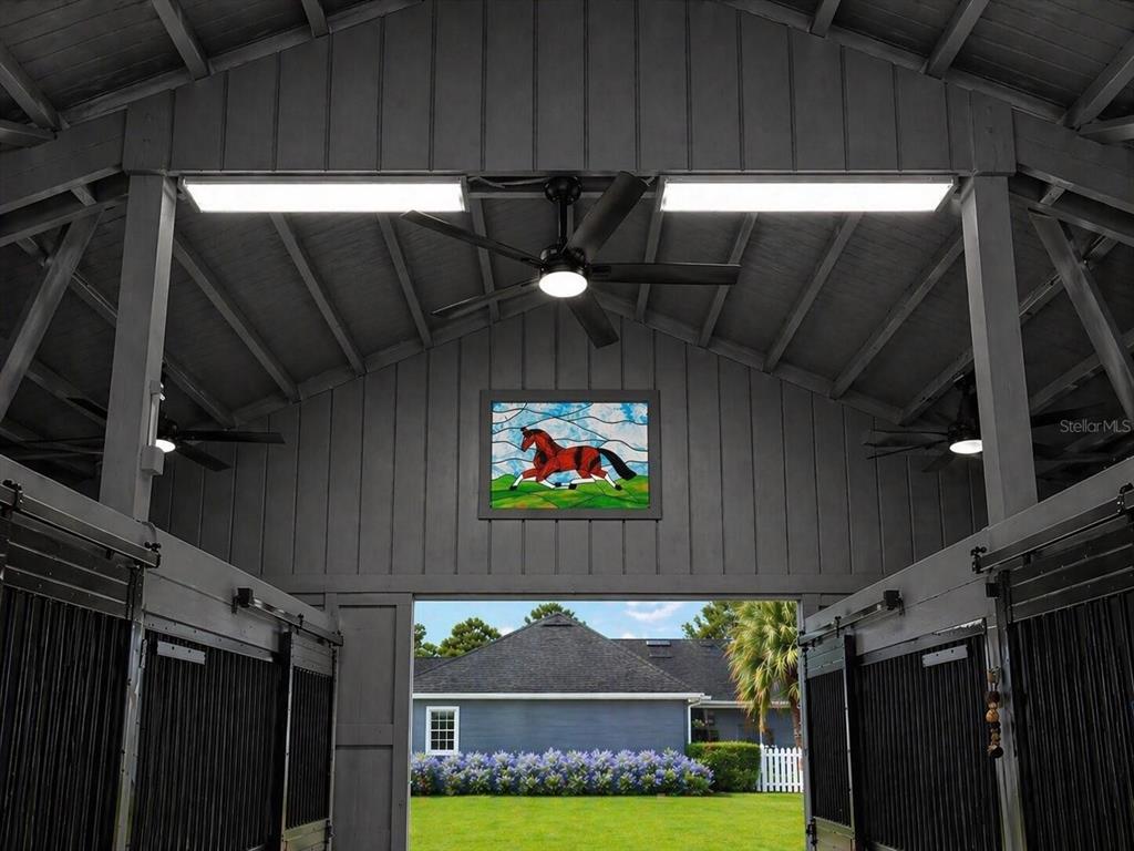 A view from inside a horse stable looking out toward a house and lawn — 33015 SAHARA COURT, SORRENTO, FL