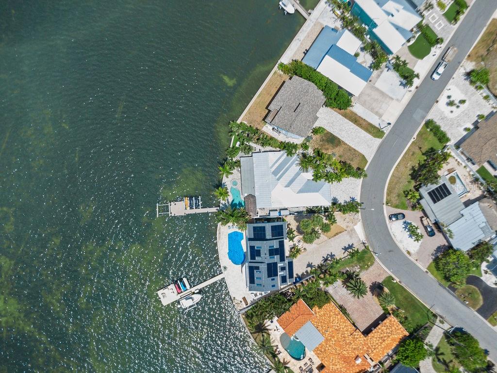 An aerial view shows waterfront homes with private docks, swimming pools, and paved driveways — 980 BOCA CIEGA ISLE DRIVE, ST PETE BEACH, FL