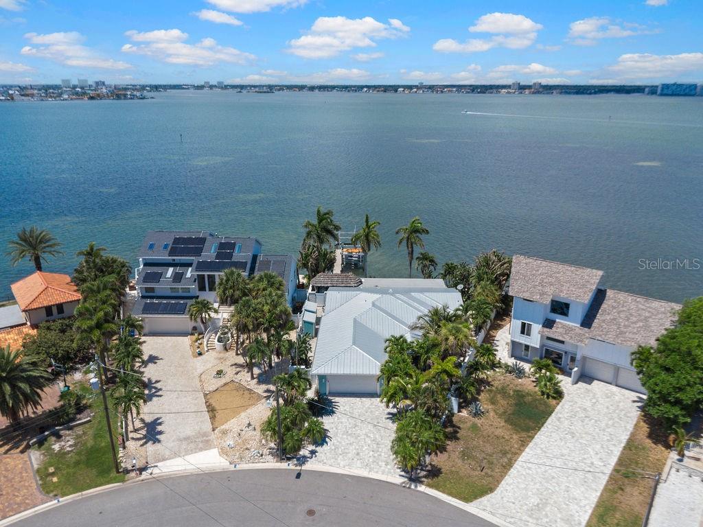 An aerial view of three waterfront houses with palm trees and a private dock — 980 BOCA CIEGA ISLE DRIVE, ST PETE BEACH, FL