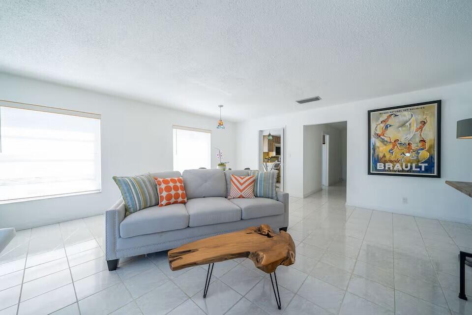 A living room features a grey sofa, a live-edge wood coffee table, and tile flooring — 6 Lucerne Avenue # 3, FL 33460, FL