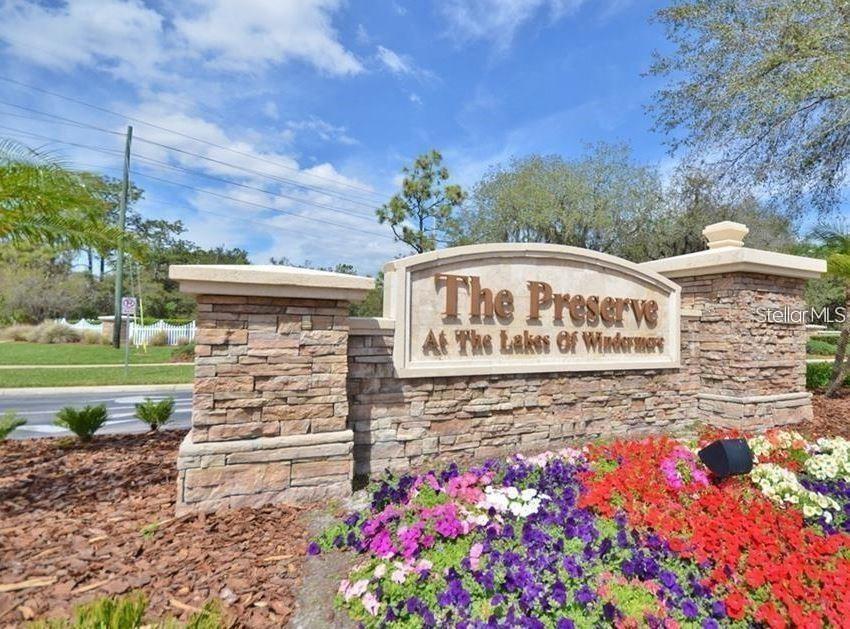 A stone monument sign for The Preserve at the Lakes of Windermere with flower beds — 8556 GREENBANK BOULEVARD, WINDERMERE, FL