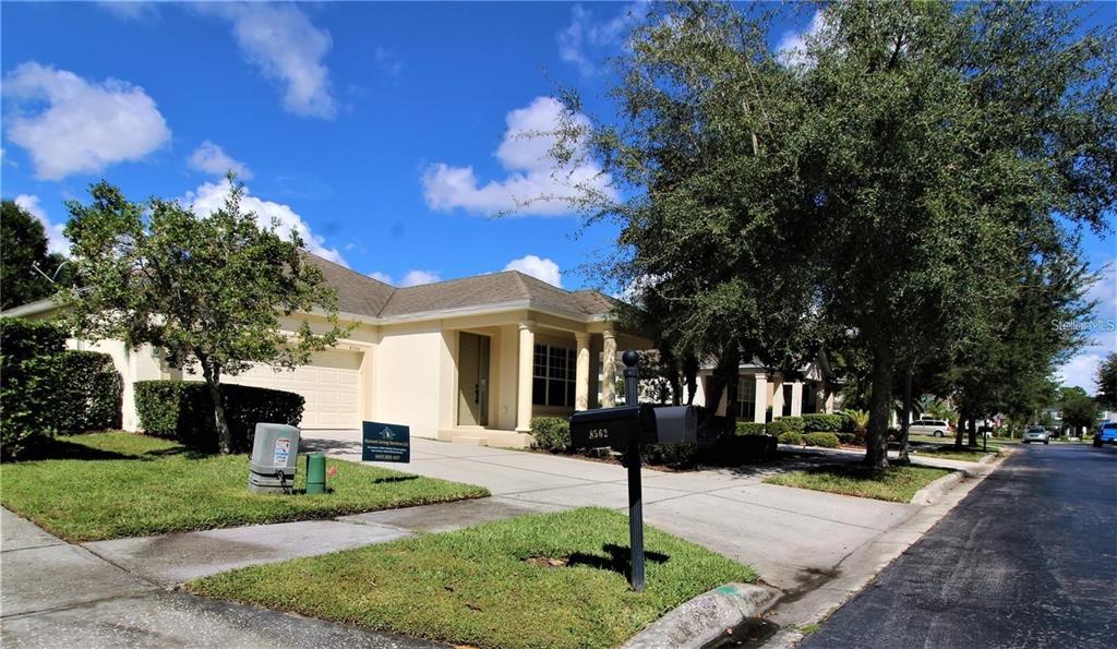 A single-story house with a beige exterior, a two-car garage, and a front driveway — 8556 GREENBANK BOULEVARD, WINDERMERE, FL