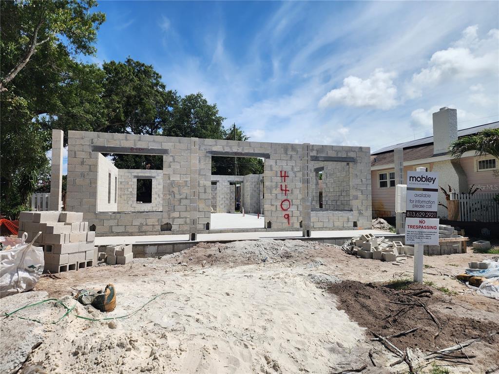 A construction site shows the concrete block walls of a new house under a blue sky — 4409 2ND AVENUE N, ST PETERSBURG, FL