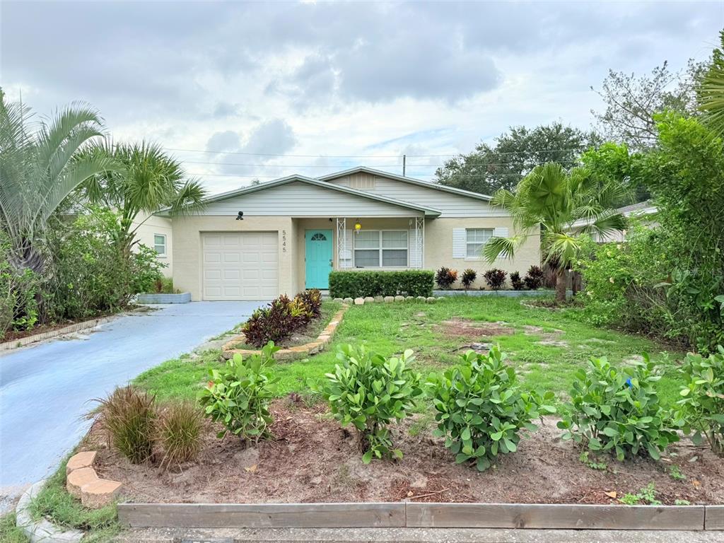 A single-story house with a light-colored exterior, a blue front door, and a front yard — 5545 3RD AVE N, ST PETERSBURG, FL