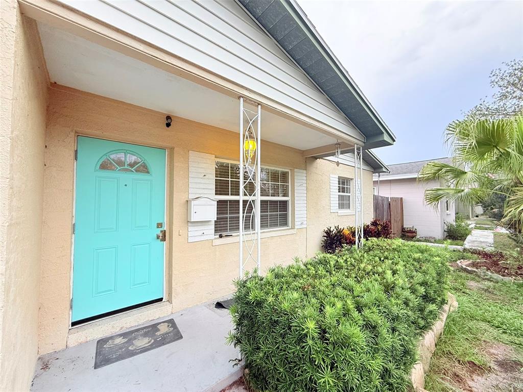 A house exterior features a light blue front door, a porch, and a large hedge — 5545 3RD AVE N, ST PETERSBURG, FL