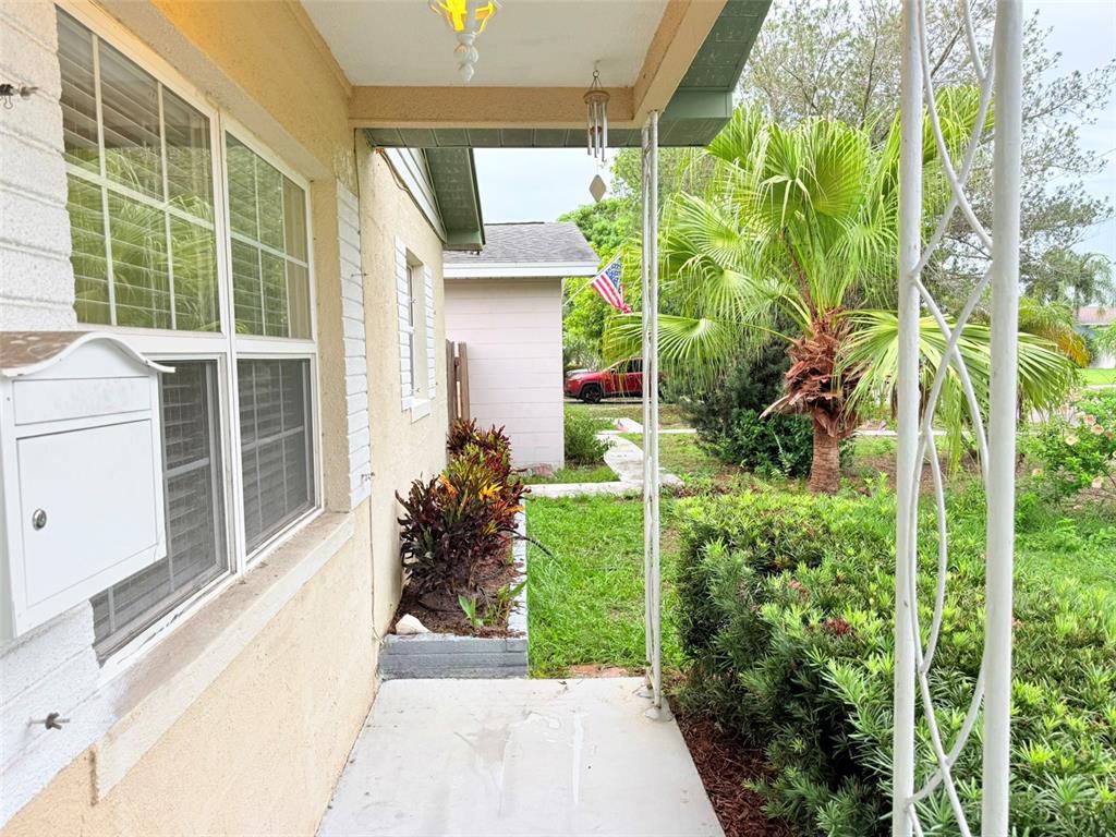 A view from a covered porch looking out toward a yard with a palm tree — 5545 3RD AVE N, ST PETERSBURG, FL