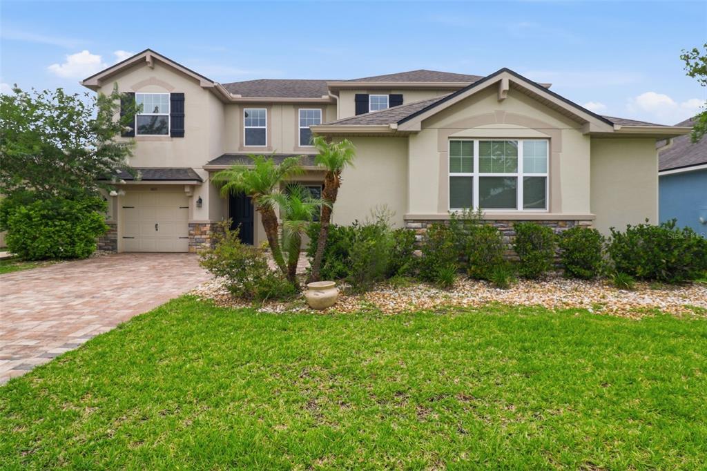 A two-story suburban house with a paved driveway, stone accents, and a front lawn — 1011 LEE SHORE STREET, VALRICO, FL