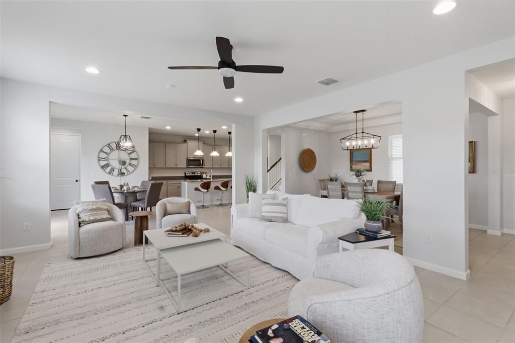 An open-concept living room features a white sofa, armchairs, and a view into the kitchen — 1011 LEE SHORE STREET, VALRICO, FL