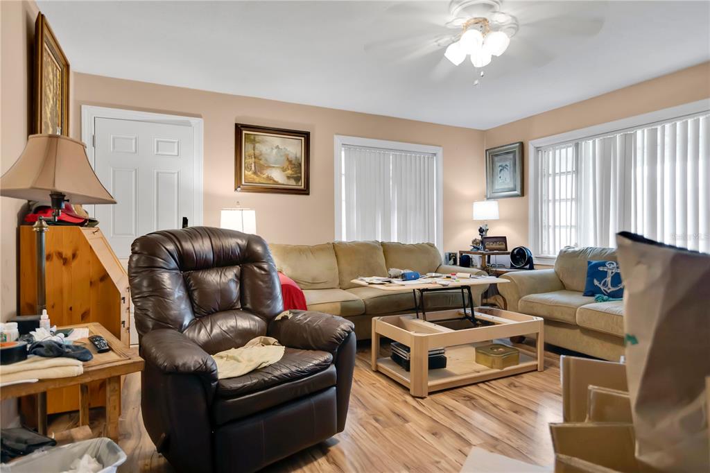 A living room features a brown leather recliner, a beige sofa, and a lift-top coffee table — 3702 CORK ROAD, PLANT CITY, FL