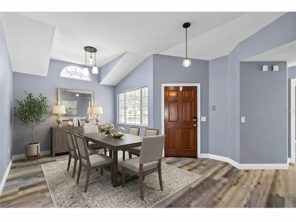 A dining room features a wooden table, six chairs, a sideboard, and a front door — 305 SAND RIDGE DRIVE, VALRICO, FL