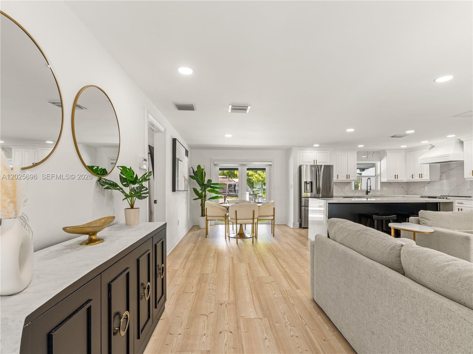 An open-concept living area features a kitchen, dining space, and light wood flooring — 1701 SW 3rd Ave, Pompano Beach FL 33060, POMPANO BEACH, FL