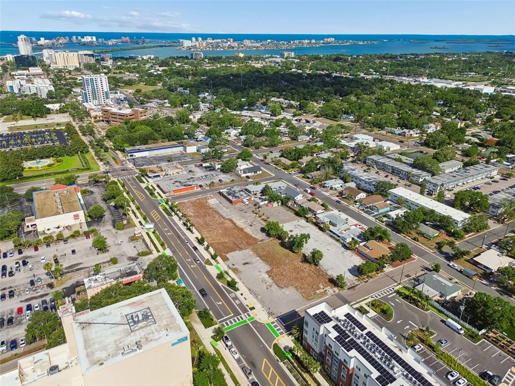 This aerial view shows a vacant lot situated between a city street and residential buildings — 1214-1242 CLEVELAND STREET, CLEARWATER, FL